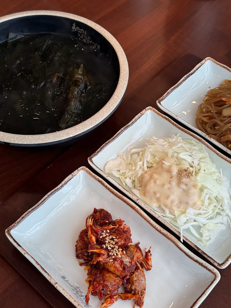 Seaweed soup, cabbage salad, and seasoned crab side dishes