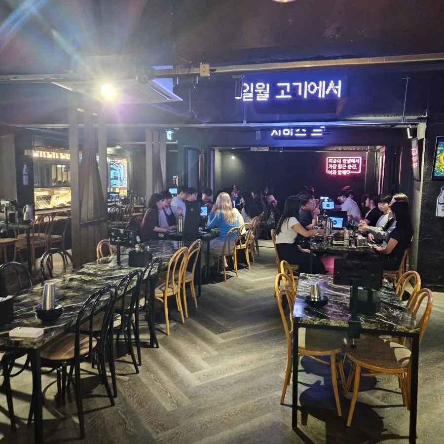 Bar interior with black tables and wood chairs