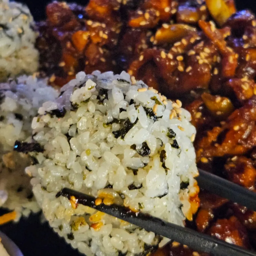 A spoonful of chibap with seasoned chicken over seaweed-flake rice