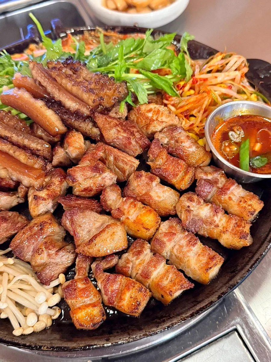 Grilled meat served with kimchi and bean sprouts on the side