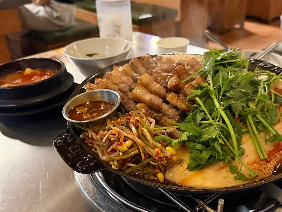 삼겹한판과 김치찌개, 계란찜, 볶음밥이 놓인 상차림