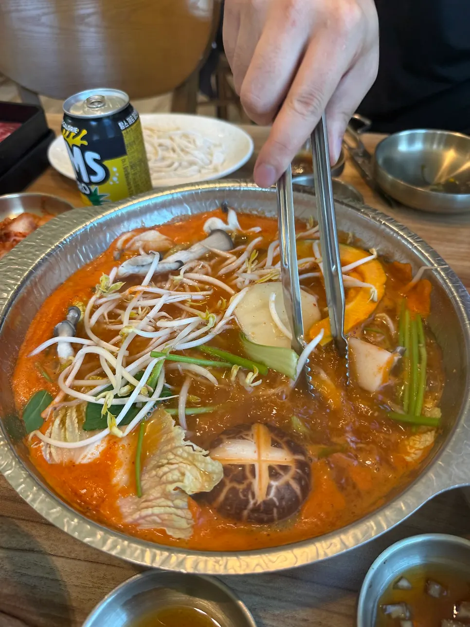 Pot of vegetables in red broth mixed with spicy seasoning paste