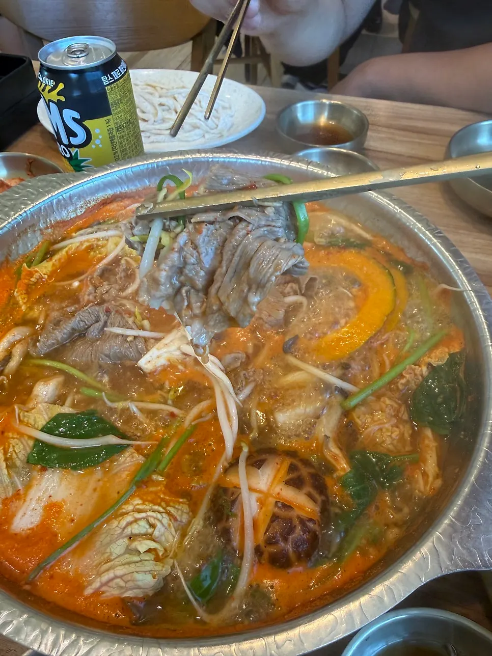 Shabu-shabu meat cooked in spicy broth with two dipping sauces
