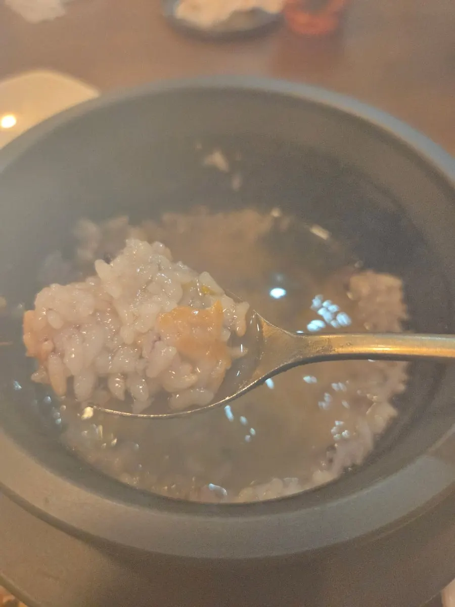 Stone pot with rice scooped out and water poured in