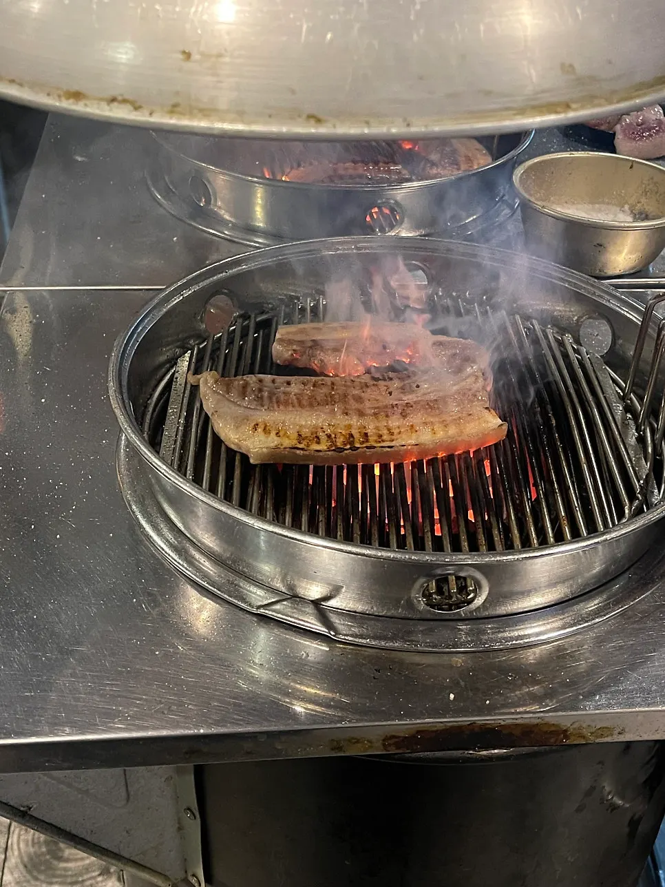 사장님이 연탄불에 흑돼지를 굽는 모습