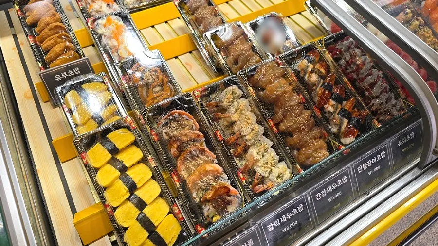 Refrigerated showcase of takeout sushi at Minyeong Hwareo Gongjang