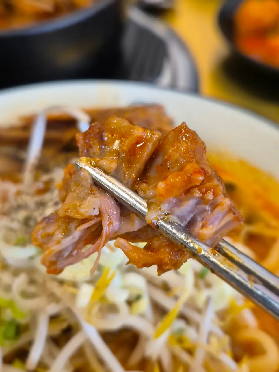 불뼈찜 한 점을 집어 든 모습