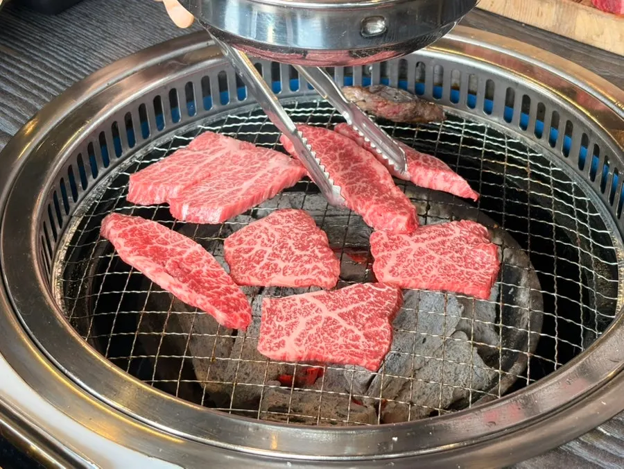 Table with hanwoo cuts alongside basic side dishes