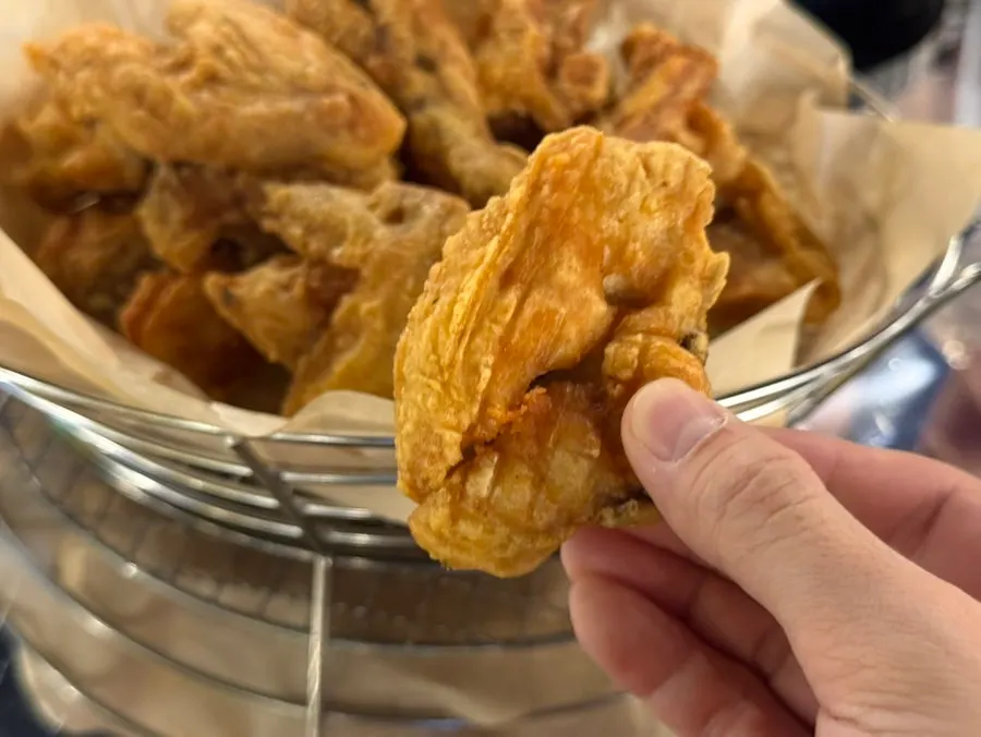 A piece of fried chicken being picked up
