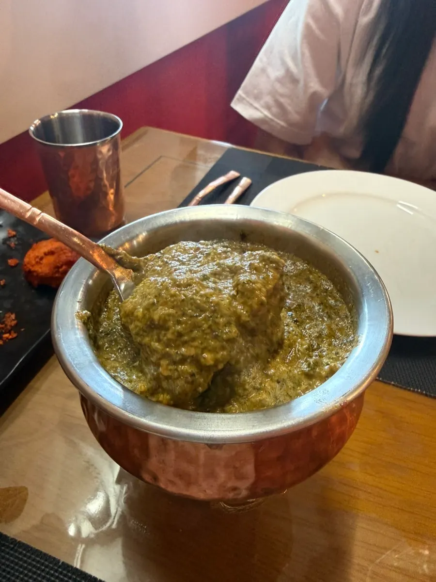 Naan dipped into butter chicken curry