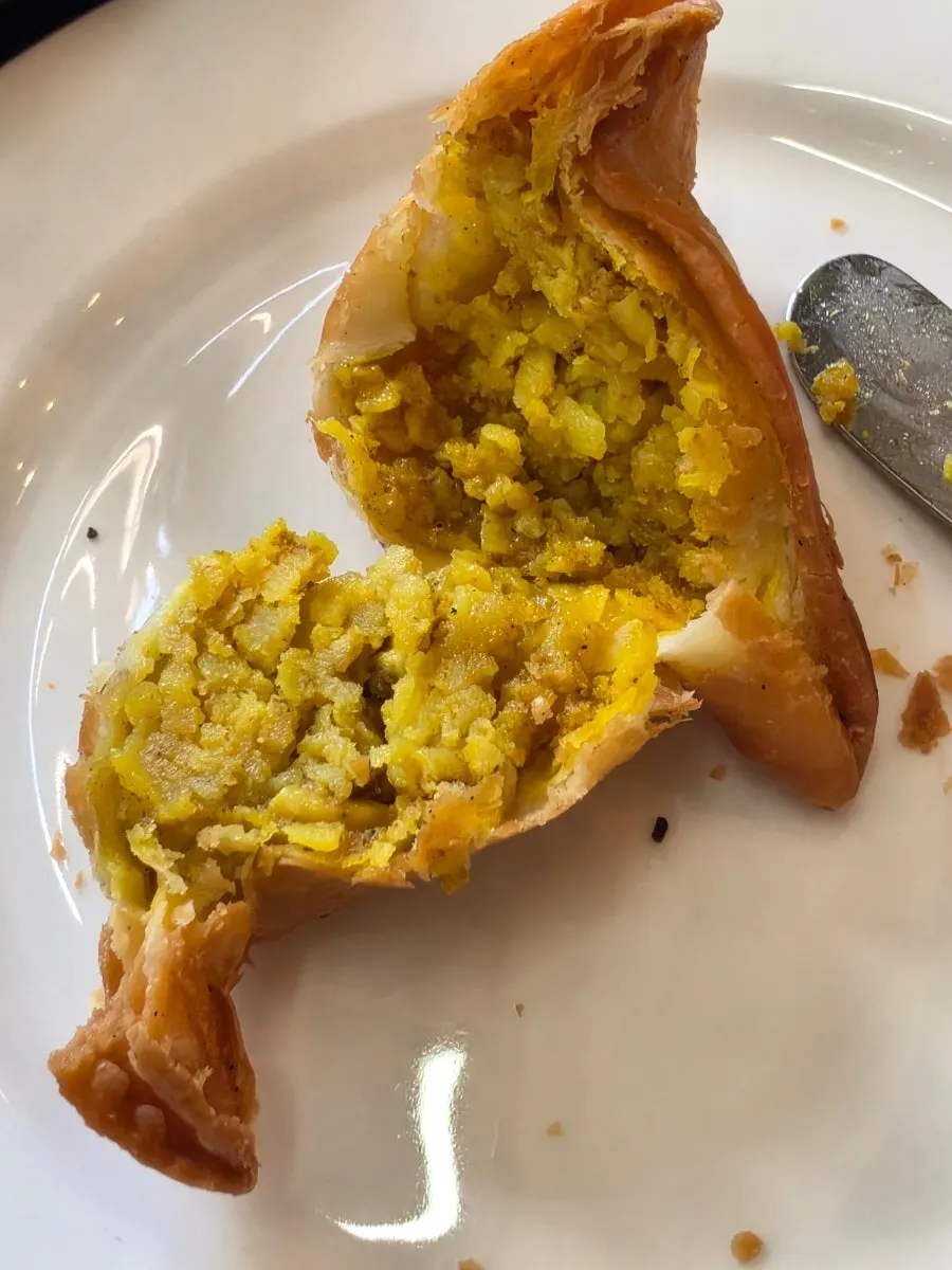 Samosa dipped into sweet-and-sour sauce