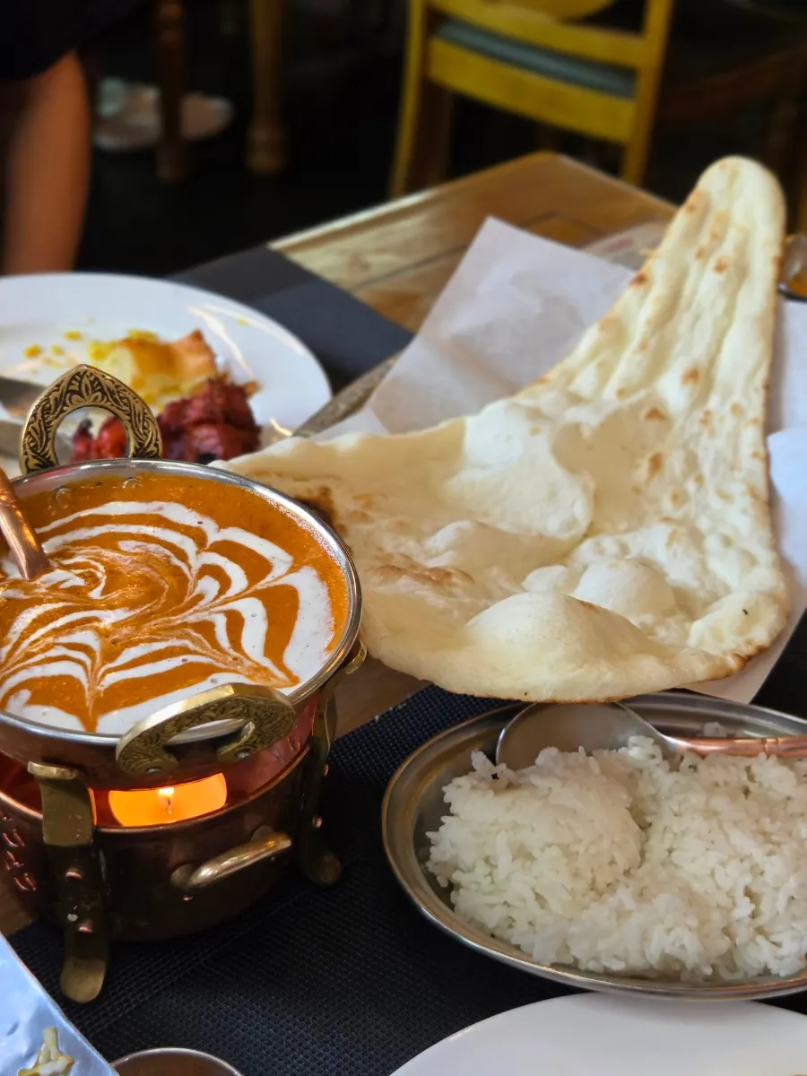 Butter curry, naan and rice served on a warmer