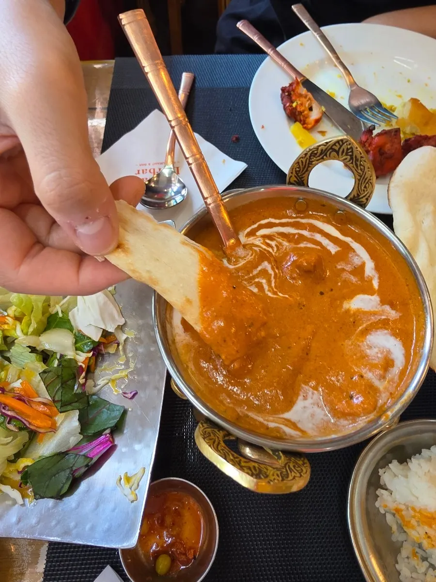A bite of naan piled high with butter curry