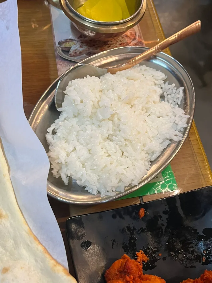 A piece of naan generously coated in curry