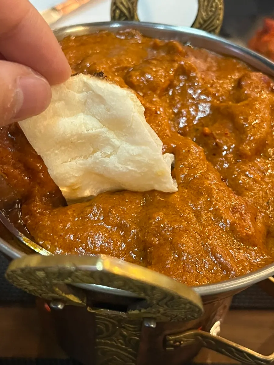Tandoori chicken placed on top of naan