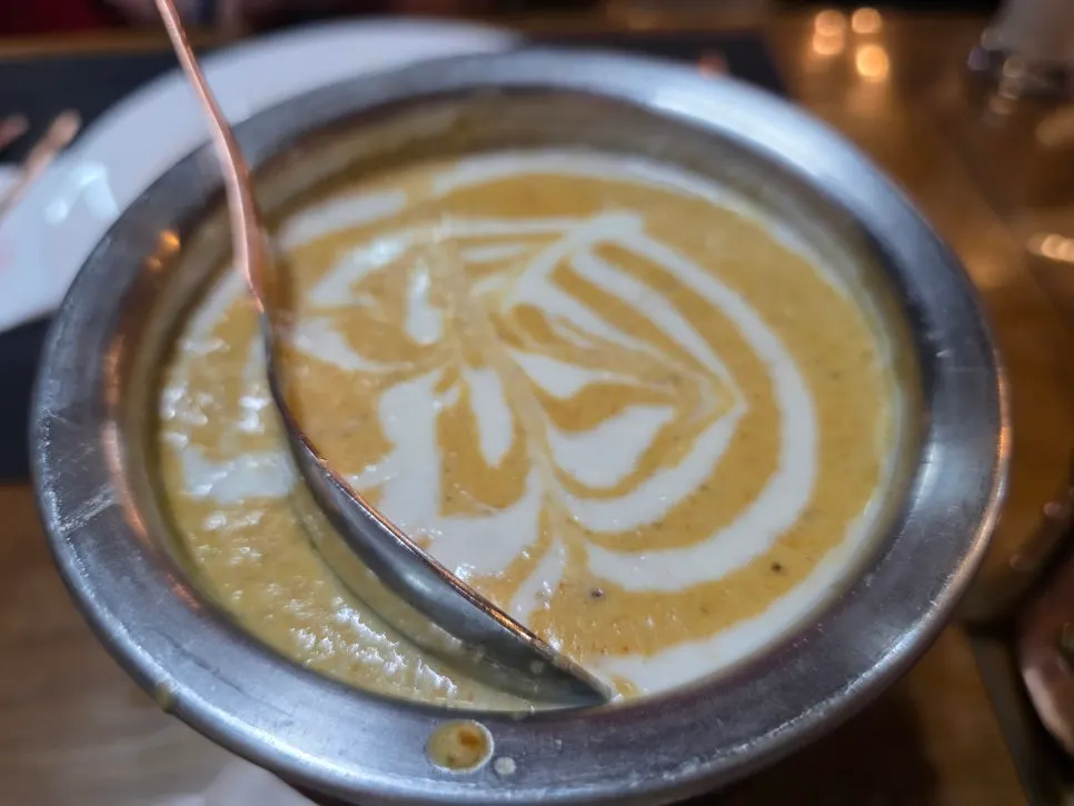 Two bowls of butter chicken curry and mutton korma curry