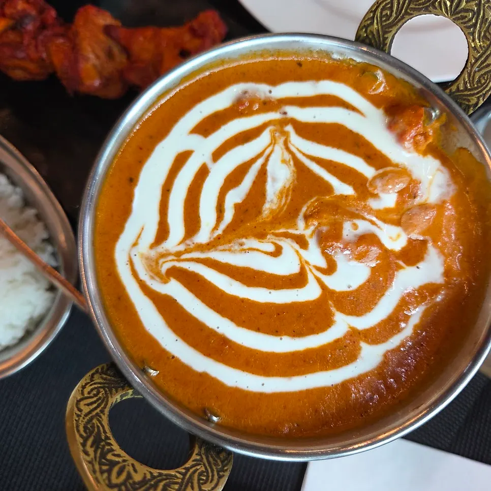 ナンにバターチキンカレーをつけた様子