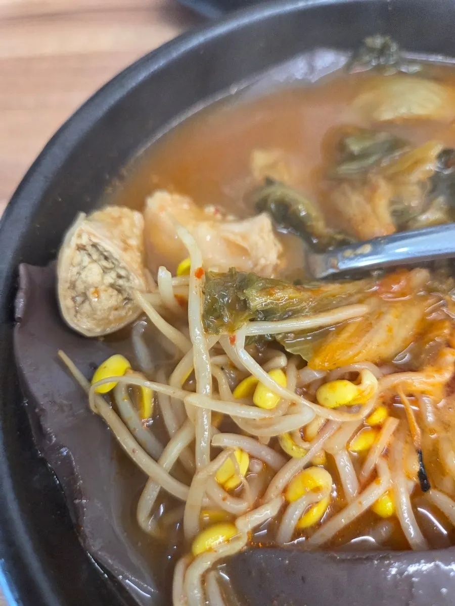 A spoonful of tripe lifted from the bowl