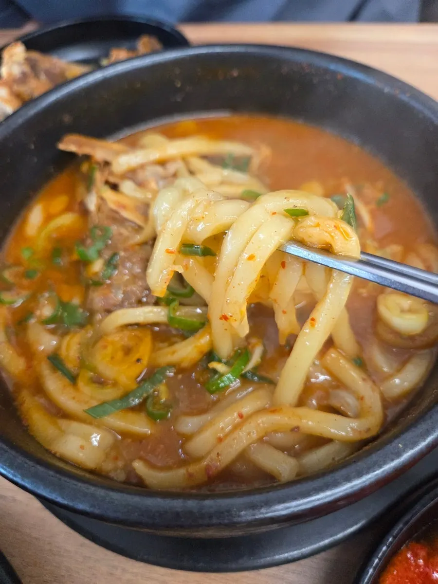 A bowl blending spicy broth and udon noodles