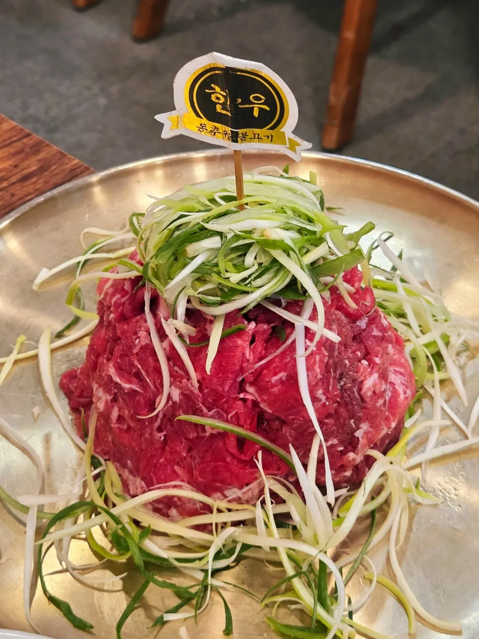 Vivid red Korean beef bulgogi topped with shredded green onion