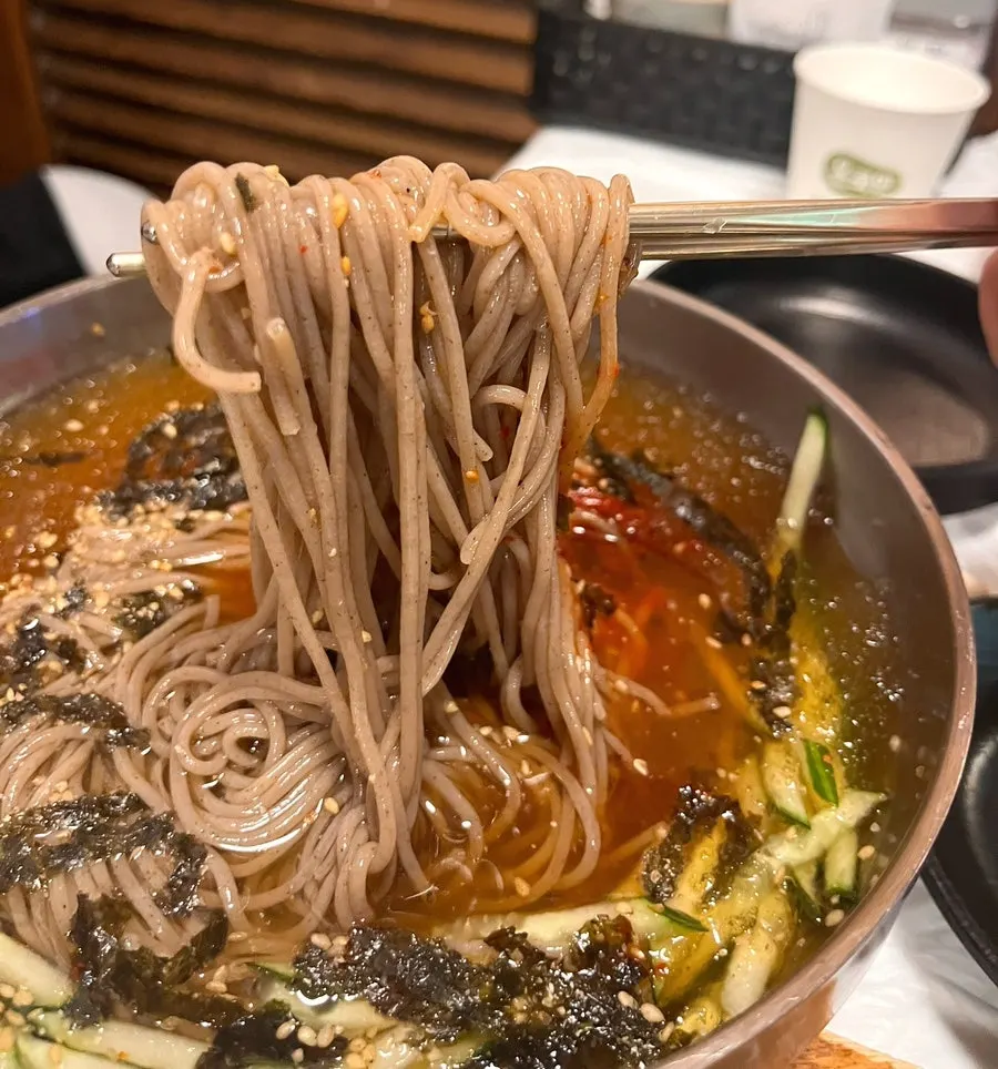 Noodles lifted from the water makguksu bowl