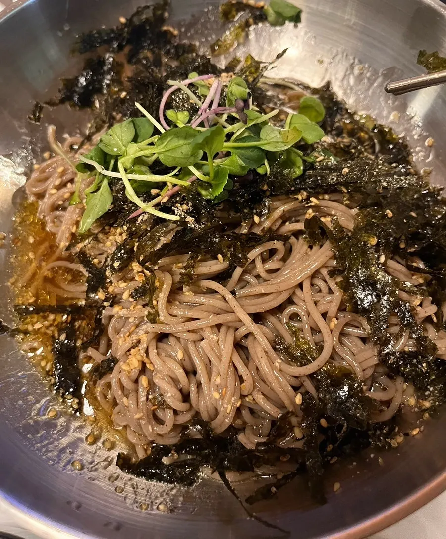 Perilla oil makguksu topped generously with gim flakes