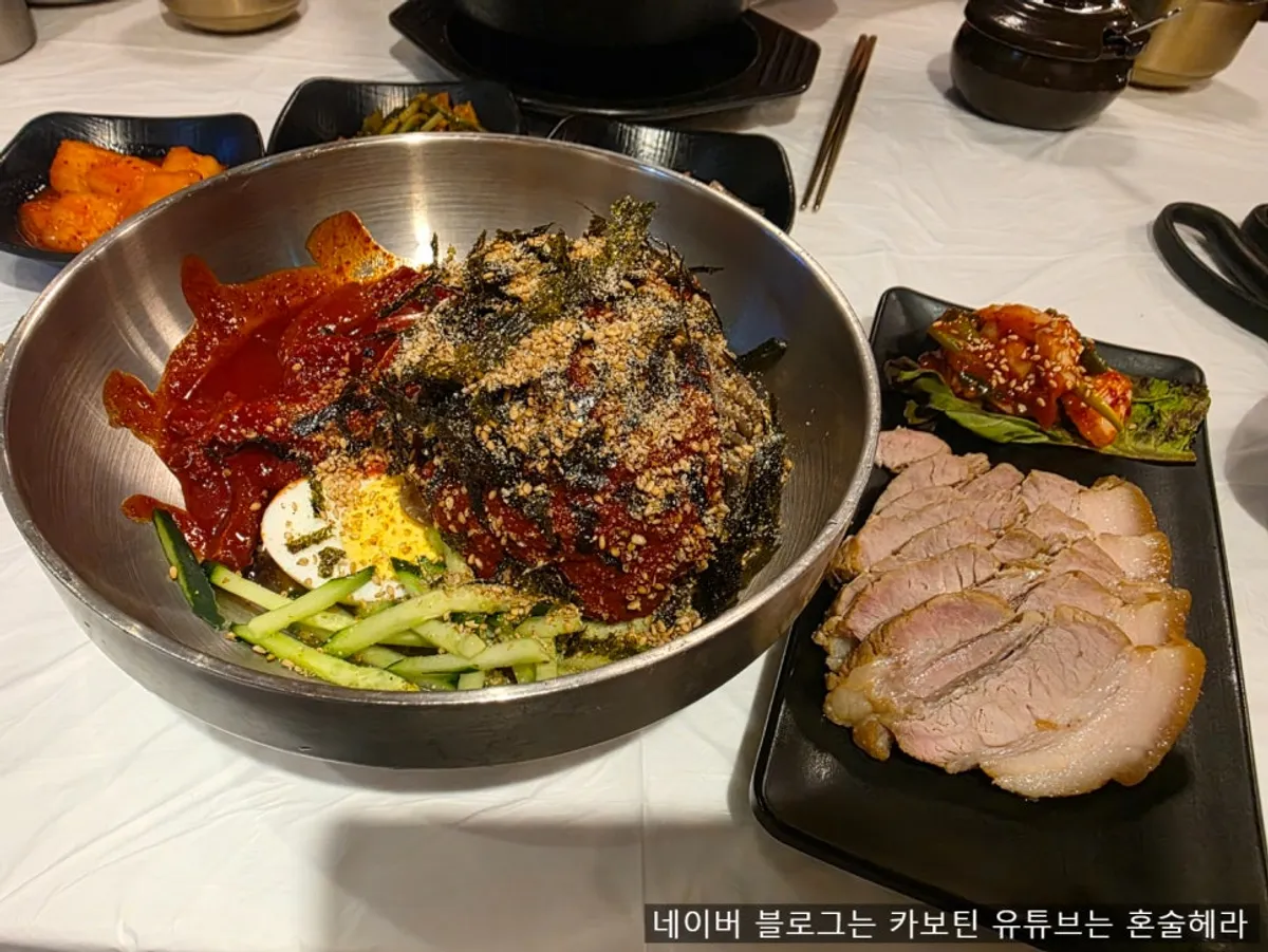 Table with stone bowl bibimbap and other Korean dishes