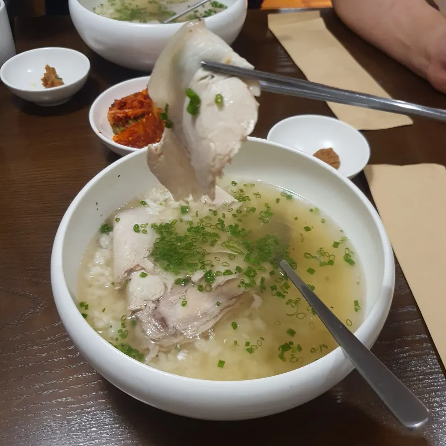 곰탕 위에 김치를 올린 한 숟갈