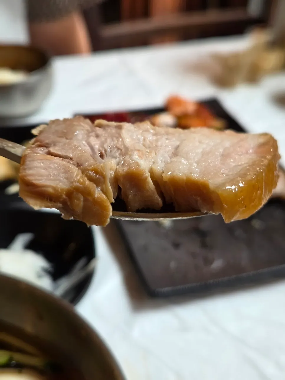 Bossam served with myeongtae sikhye and green onion kimchi