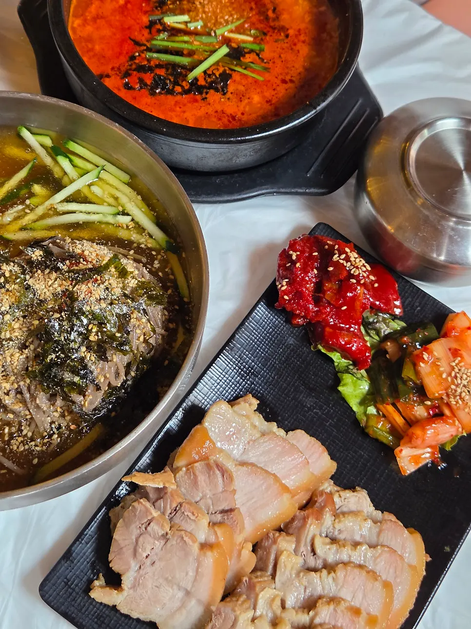 Final table spread with makguksu, bossam, and sundubu together
