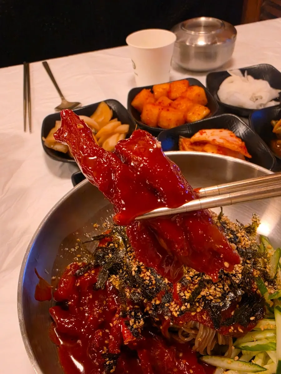 Pollock jeotgal and buckwheat noodles lifted together with chopsticks