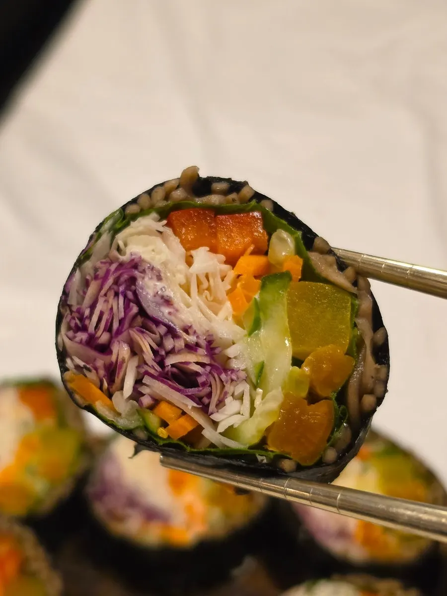 A piece of buckwheat gimbap picked up with chopsticks
