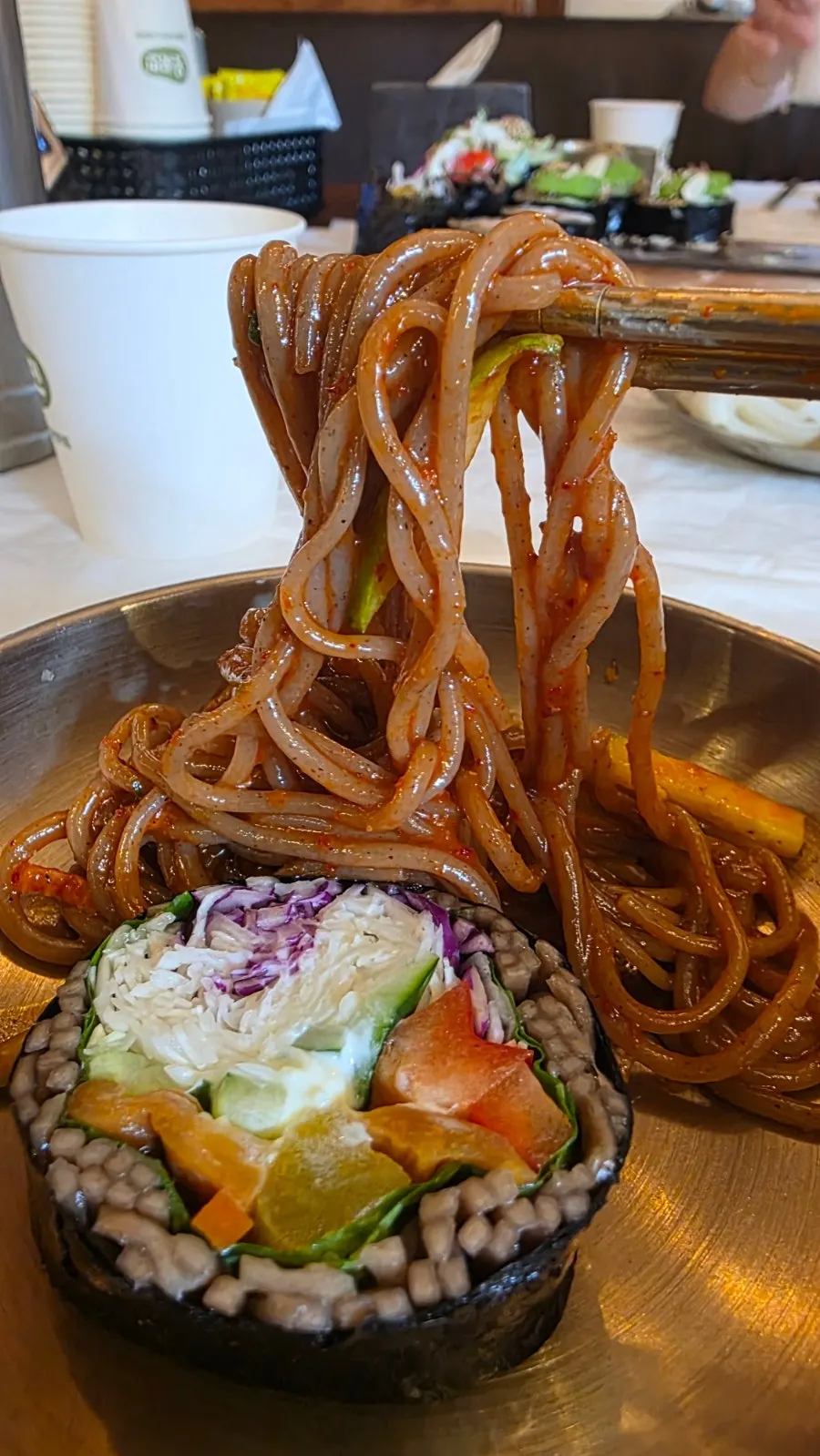 Table with bibim-makguksu and avocado buckwheat gimbap together