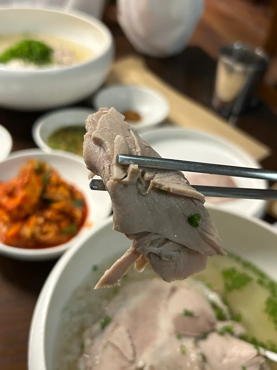 A piece of cold jeyuk with the gomtang spread