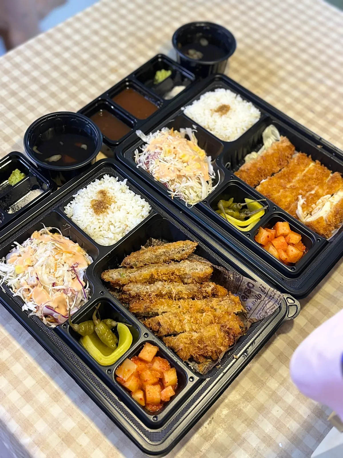 Opened tonkatsu lunchbox with rice and side dishes