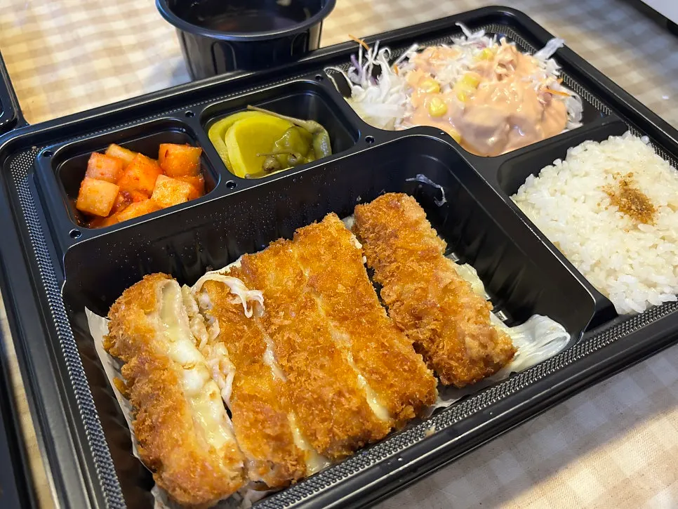 Cheese tonkatsu cut open with cheese stretching out