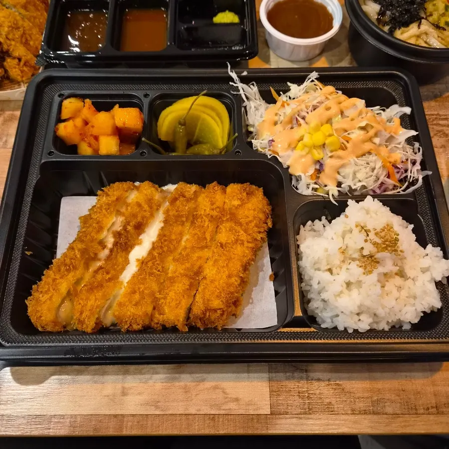 밥과 샐러드, 깍두기가 함께 담긴 치즈 도시락