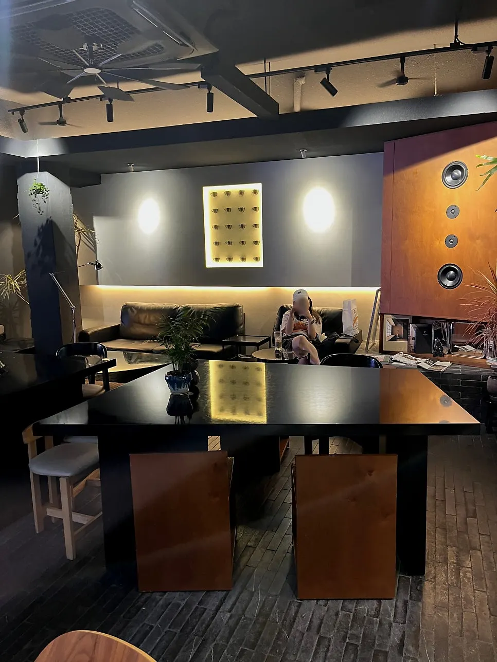 Café interior mixing black furniture and wood