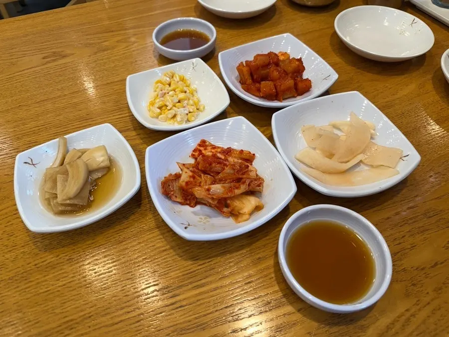 Meat broth and side dishes set before the meal