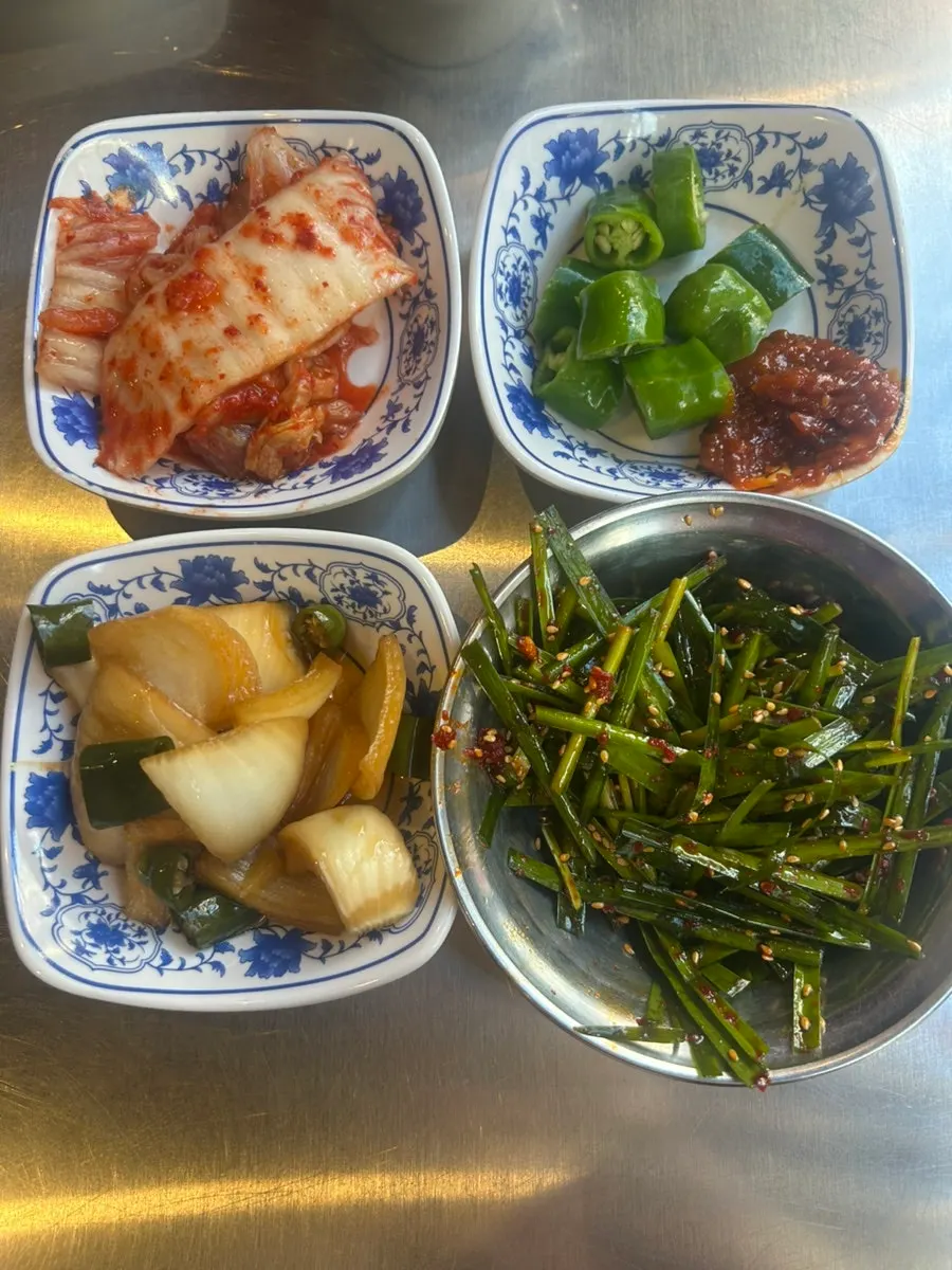 Side dishes including pickles and seasoned scallions