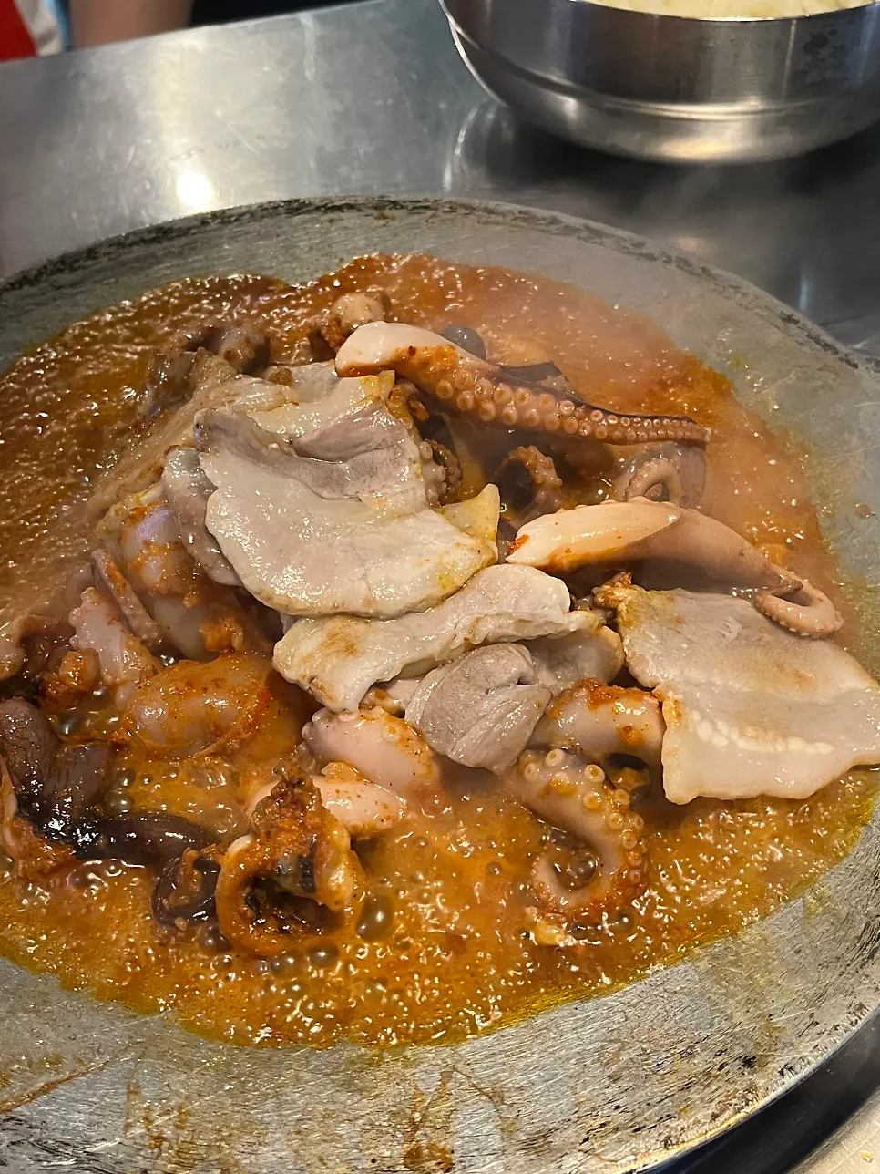 살짝 익힌 삼겹살을 쭈꾸미 양념에 넣는 모습