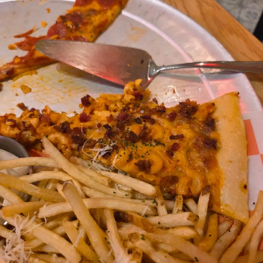 Meat-topped pizza slice with macaroni on top