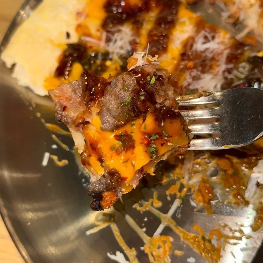 A bitten slice of American Bulbeok Pizza