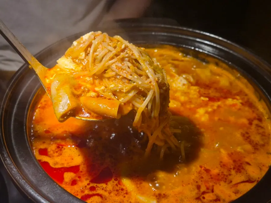 Broth and jjolmyeon noodles in the beef tripe soft tofu hotpot