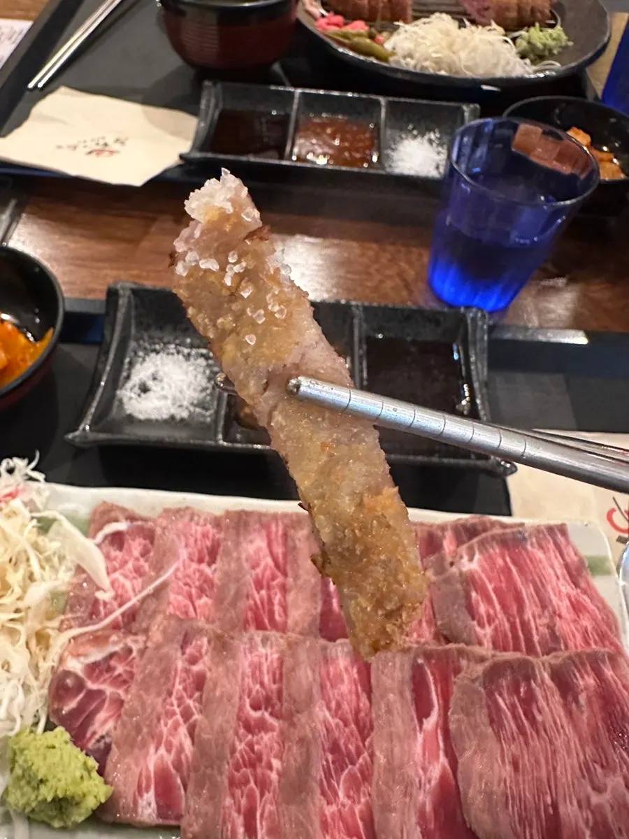 A piece of gyukatsu grilling on the personal brazier