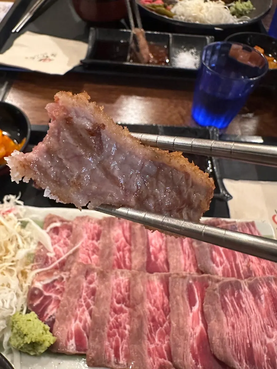 A piece of gyukatsu with wasabi and dipping sauces