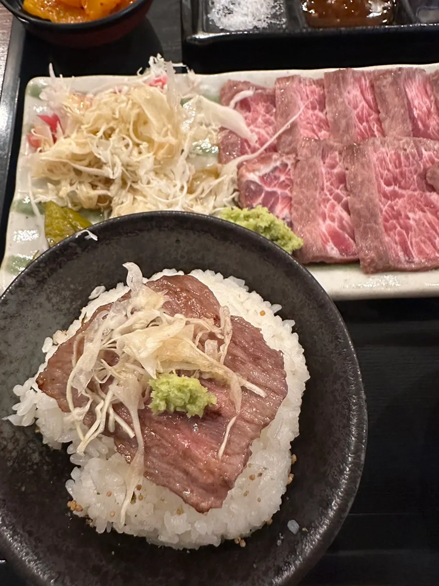 A piece of steki with salt and wasabi on the side