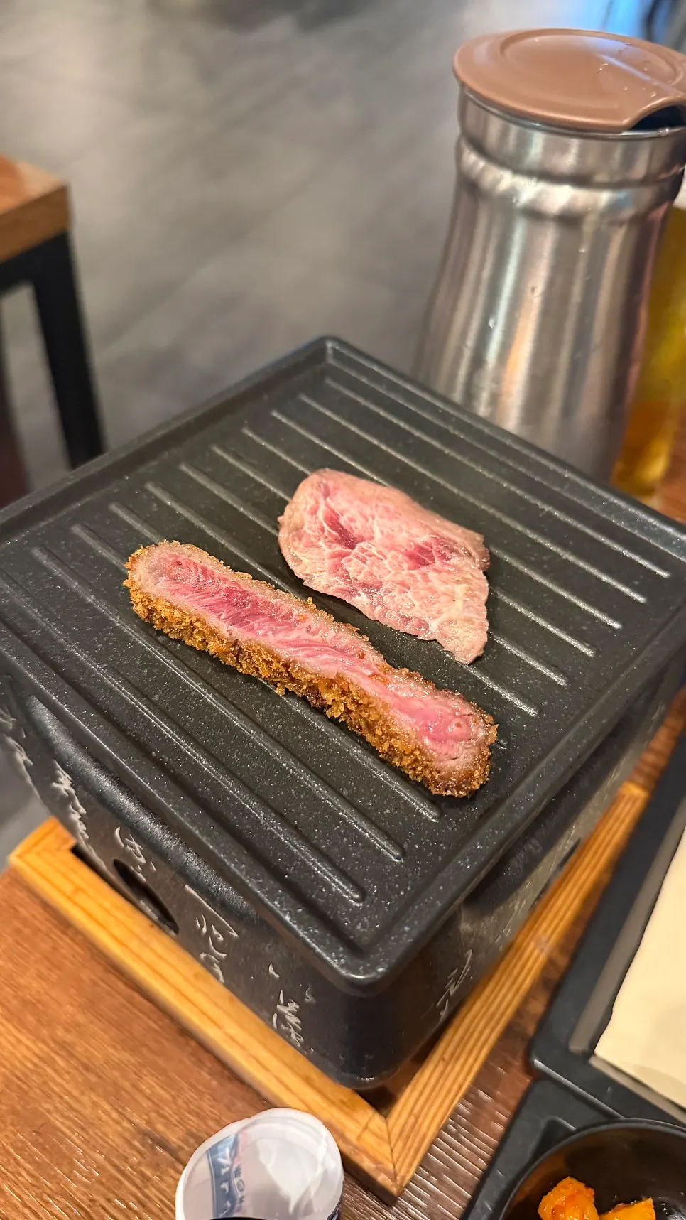 A piece of gyukatsu placed on the personal tabletop grill