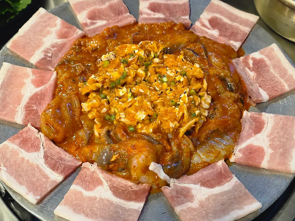 Hot plate octopus topped with raw pork belly and garlic