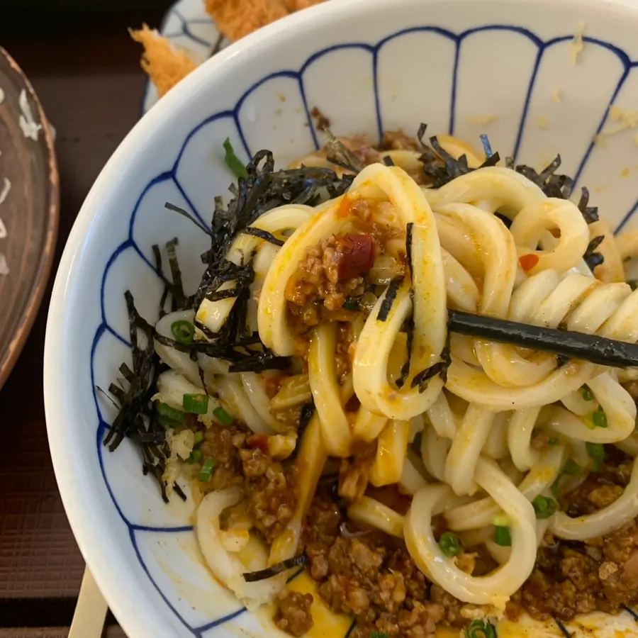 Chewy udon noodles lifted up with chopsticks